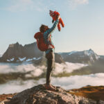 Father holding up baby hiking in mountains family fun travel vacation with child active healthy lifestyle man and infant outdoor Fathers day holiday