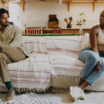 Full length shot of a young couple sitting on the sofa together and ignoring each other after an argument
