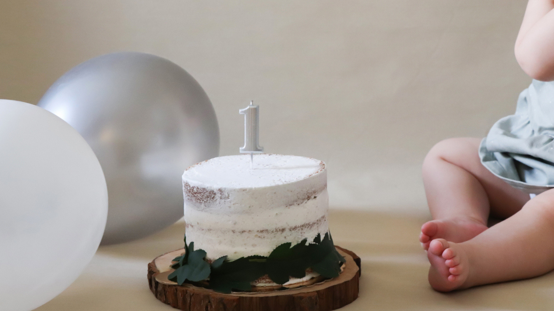 baby with first birthday smash cake