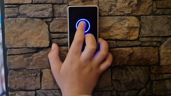 Child finger presses round touch button closeup