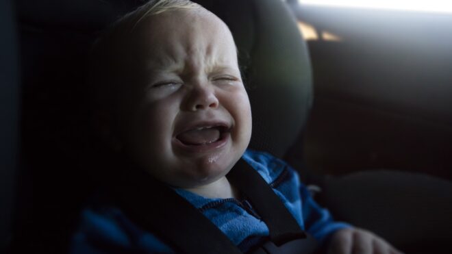 Baby boy crying in car seat