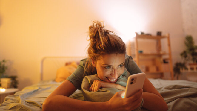 Woman using phone on bed