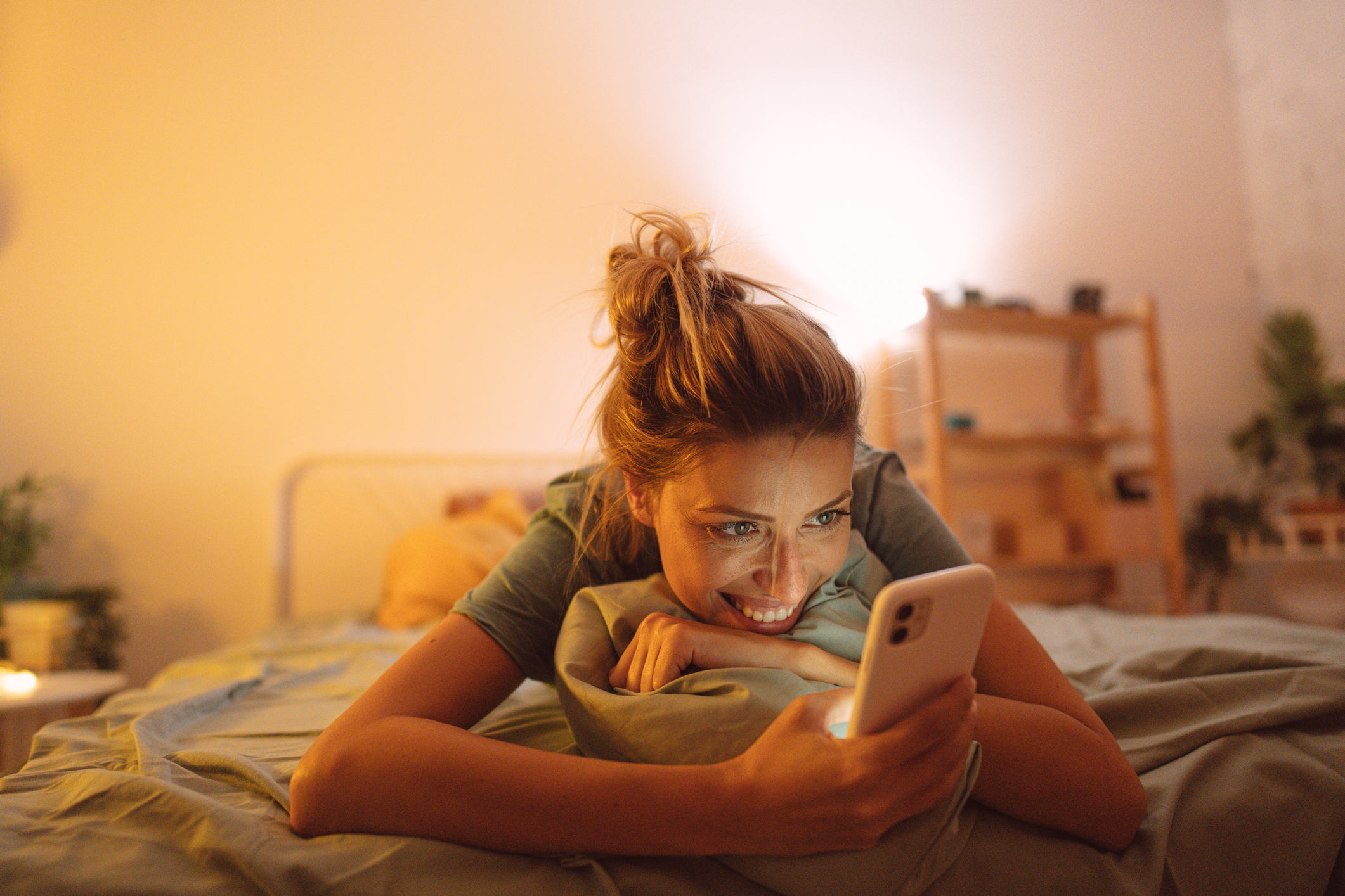 Woman using phone on bed