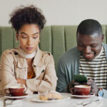 Cafe, man and ignore woman with phone for internet addiction, attention and annoyed with bad date. Interracial people, coffee shop and jealous partner for cheating, toxic relationship or overthinking