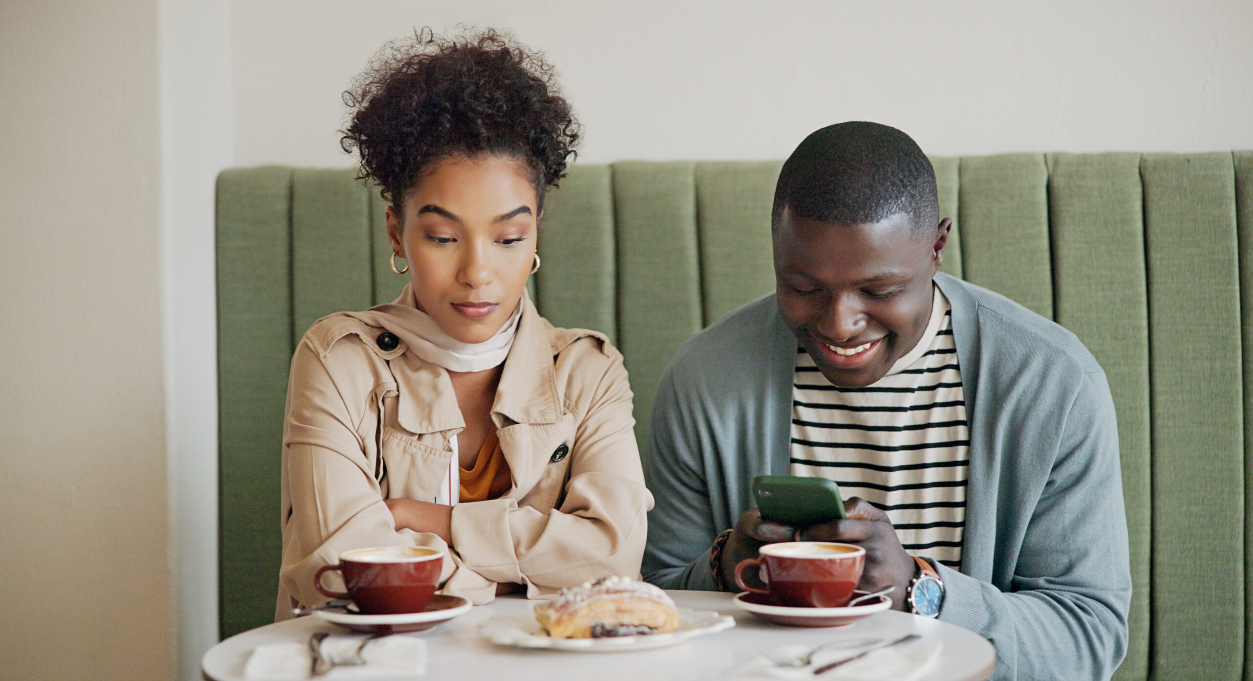Man and woman at a restaurant, man is ignoring the woman
