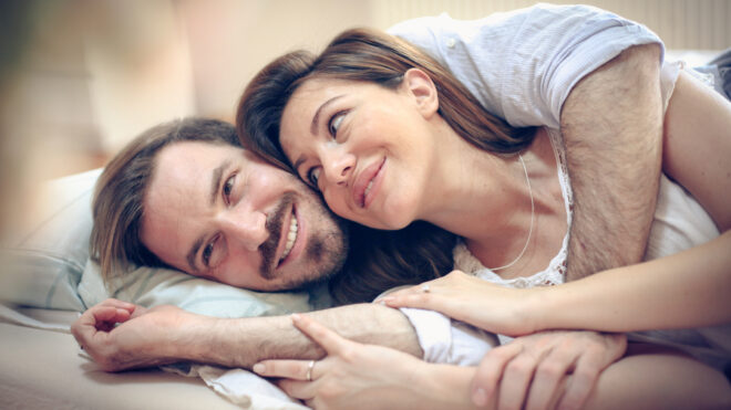 Happy young couple in bed
