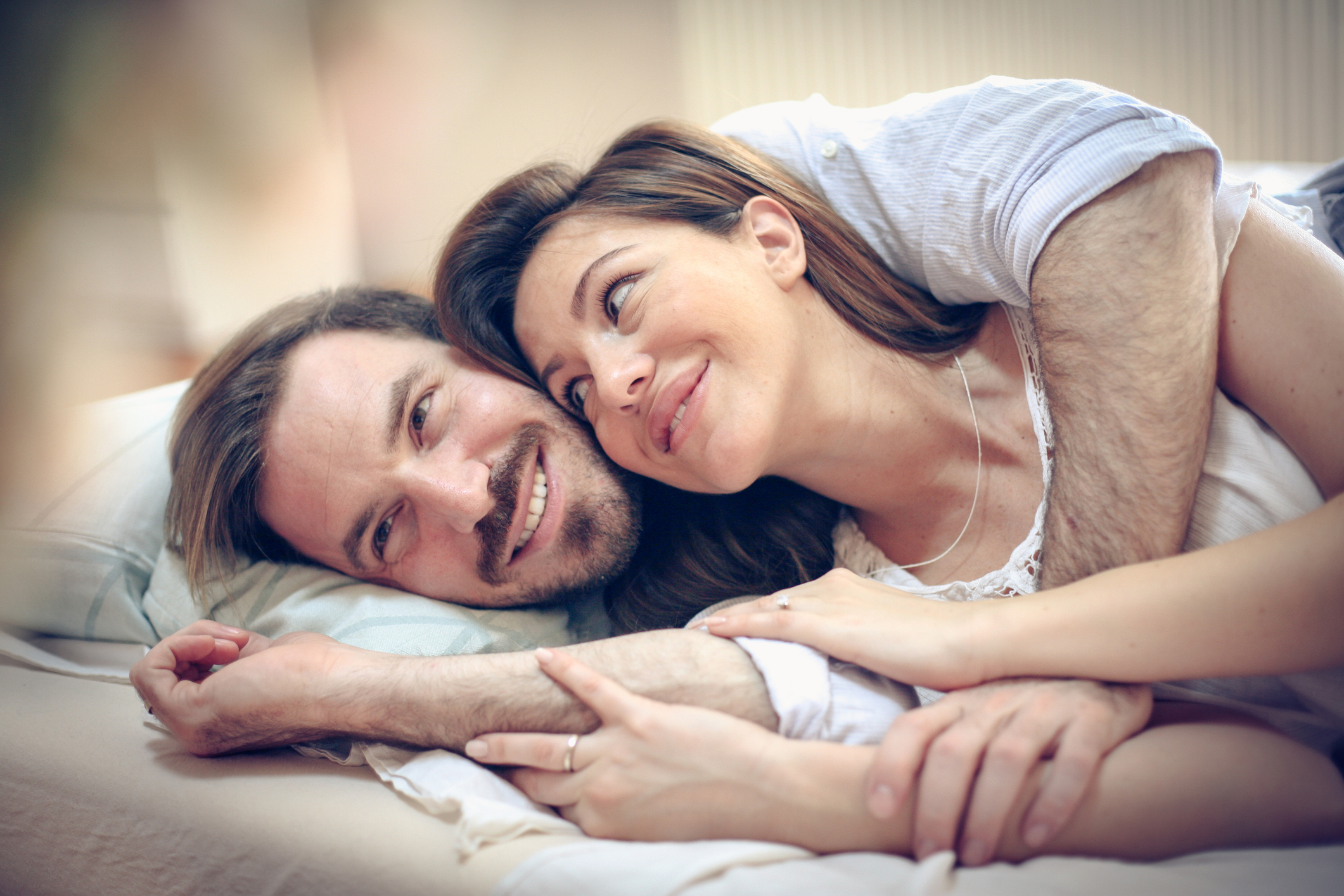 Happy young couple in bed