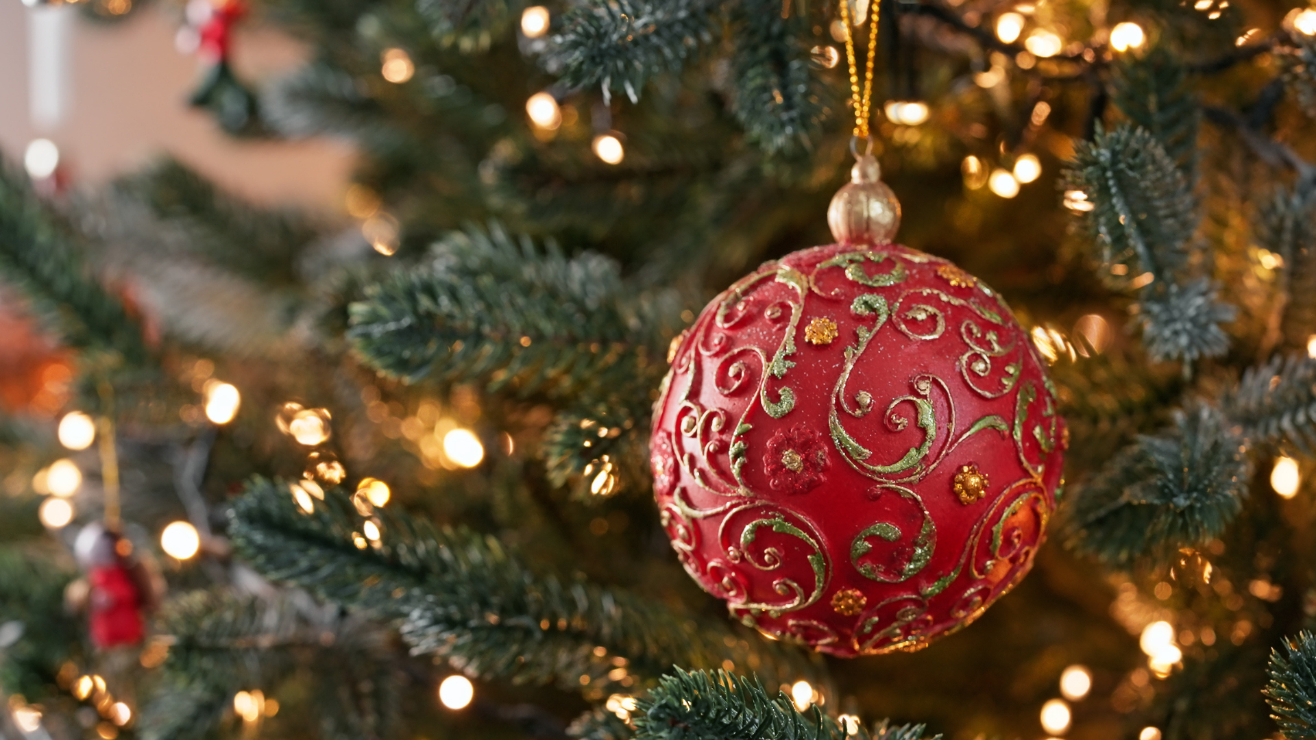 Red and gold chrismas ornament hanging on tree