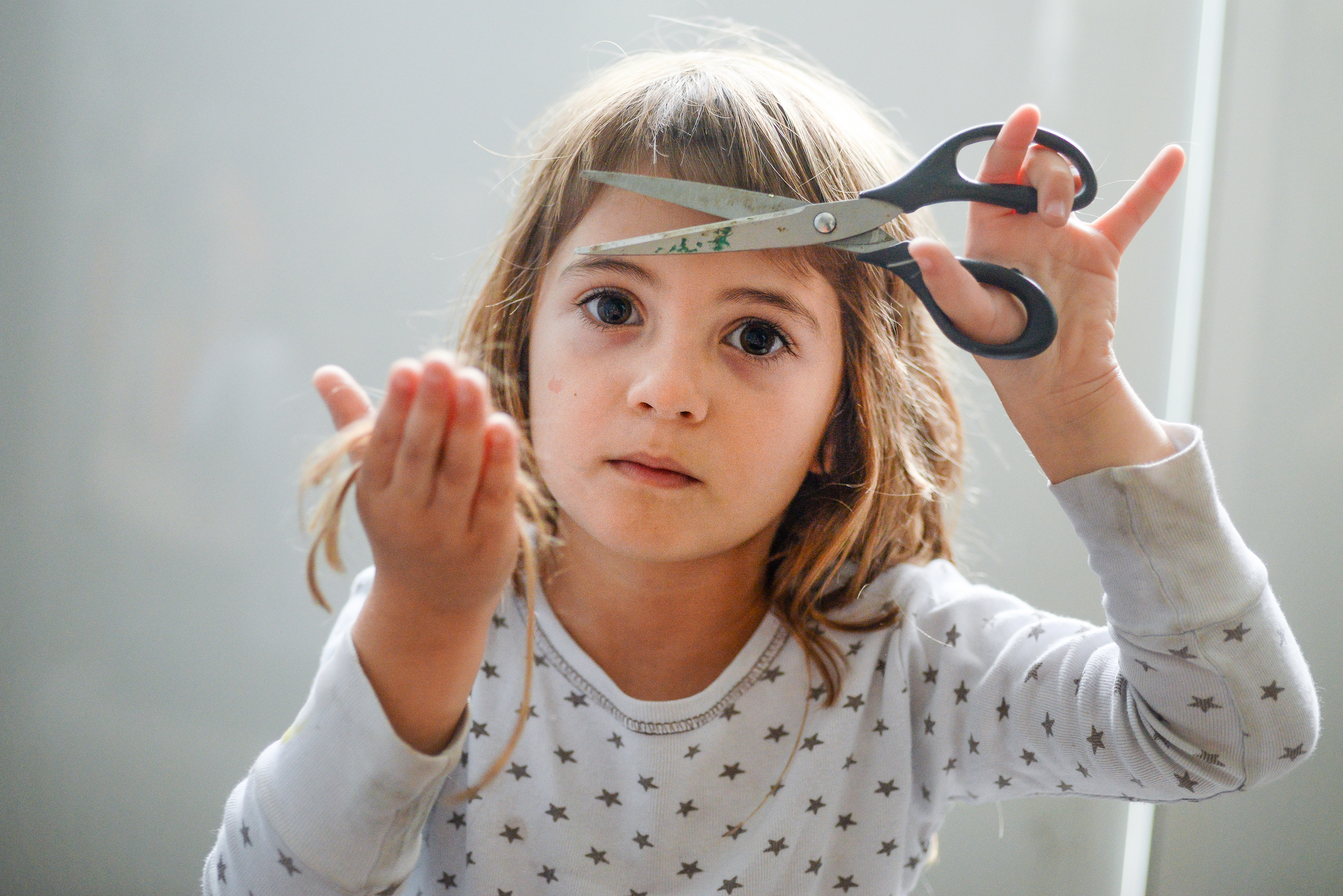 a little girl cuts her own hair