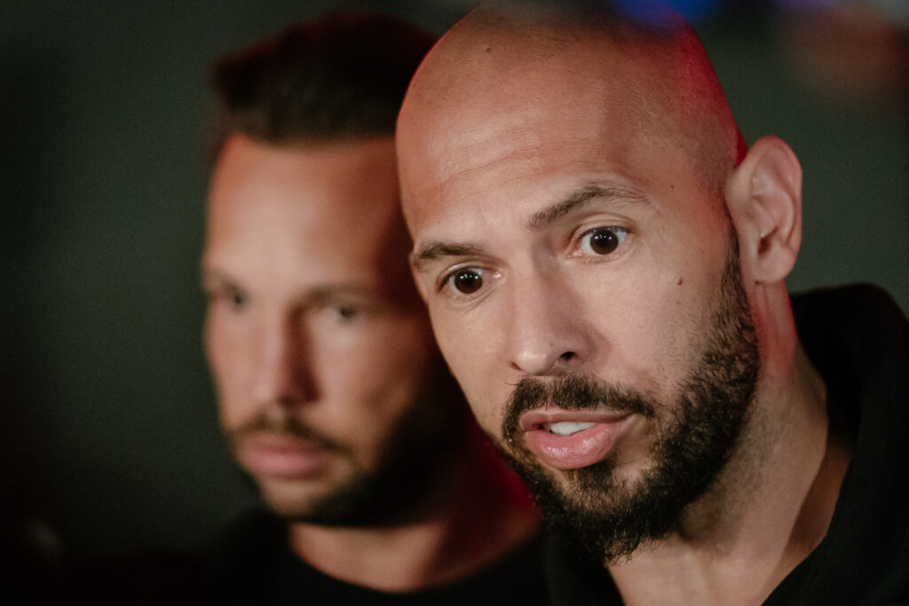 Andrew Tate and his brother Tristan Tate talk to the media outside their residence on March 23, 2025 in Bucharest, Romania