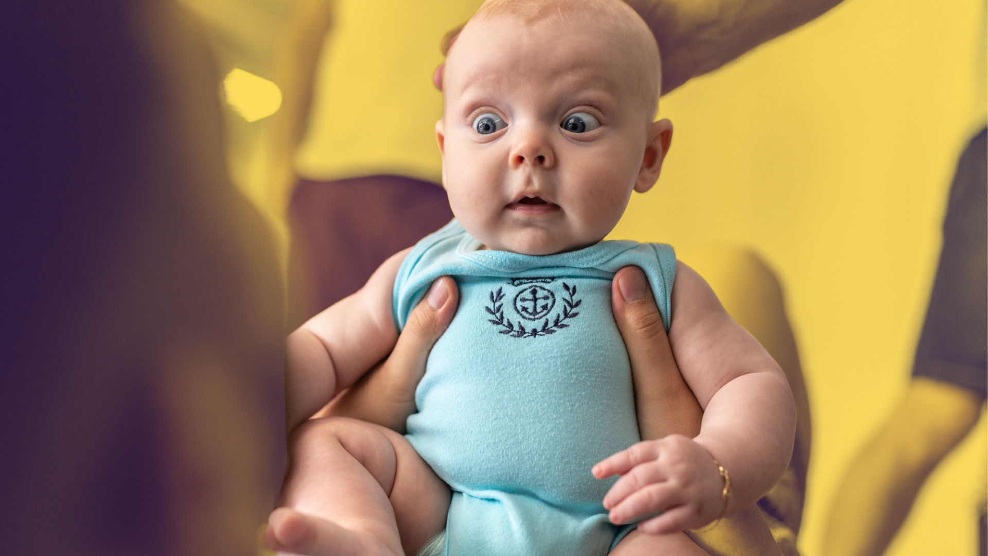 a baby in a blue onesie with a surprise look on his face
