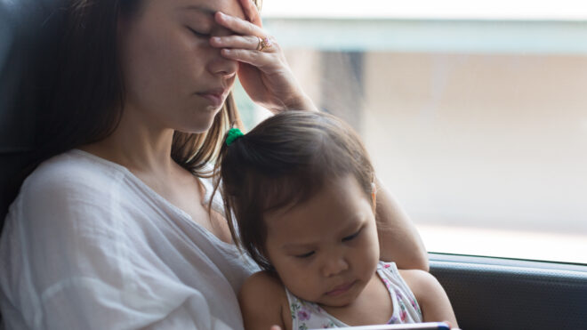 Stressed traveling theme. Long exhausting trips with children. Young mother in her 30s looks tired