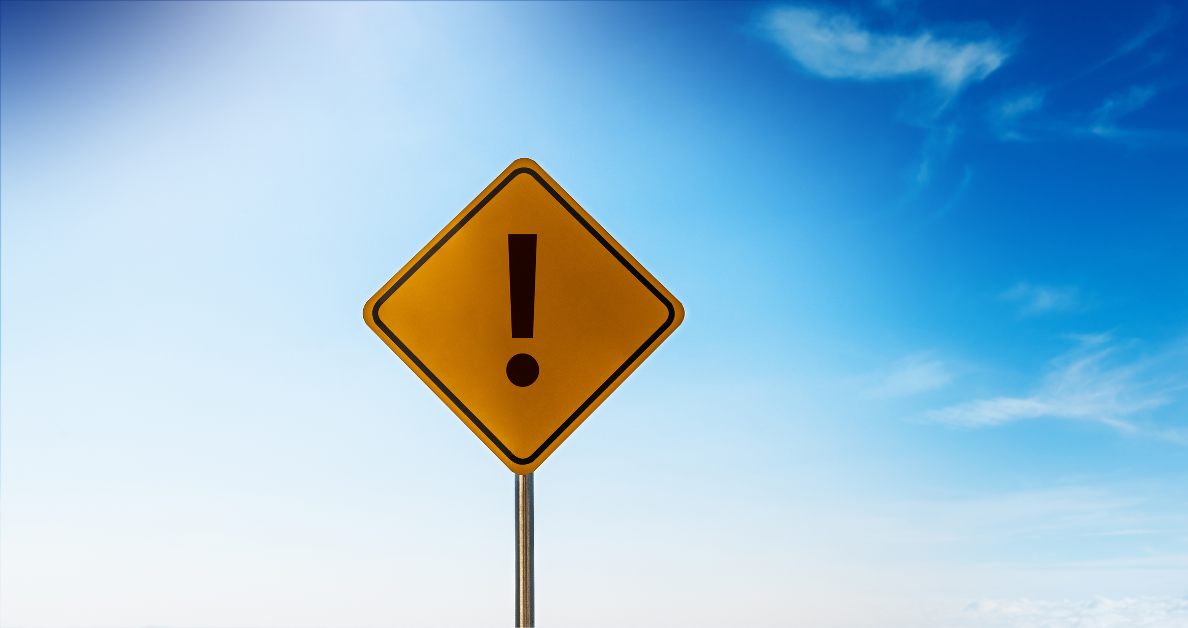 Exclamation point of attention against blue sky background