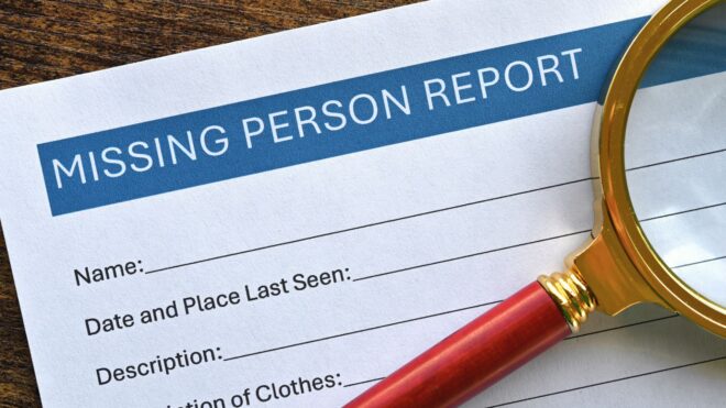 A missing person paper report that's blank and needs to be filled out with a magnifying glass