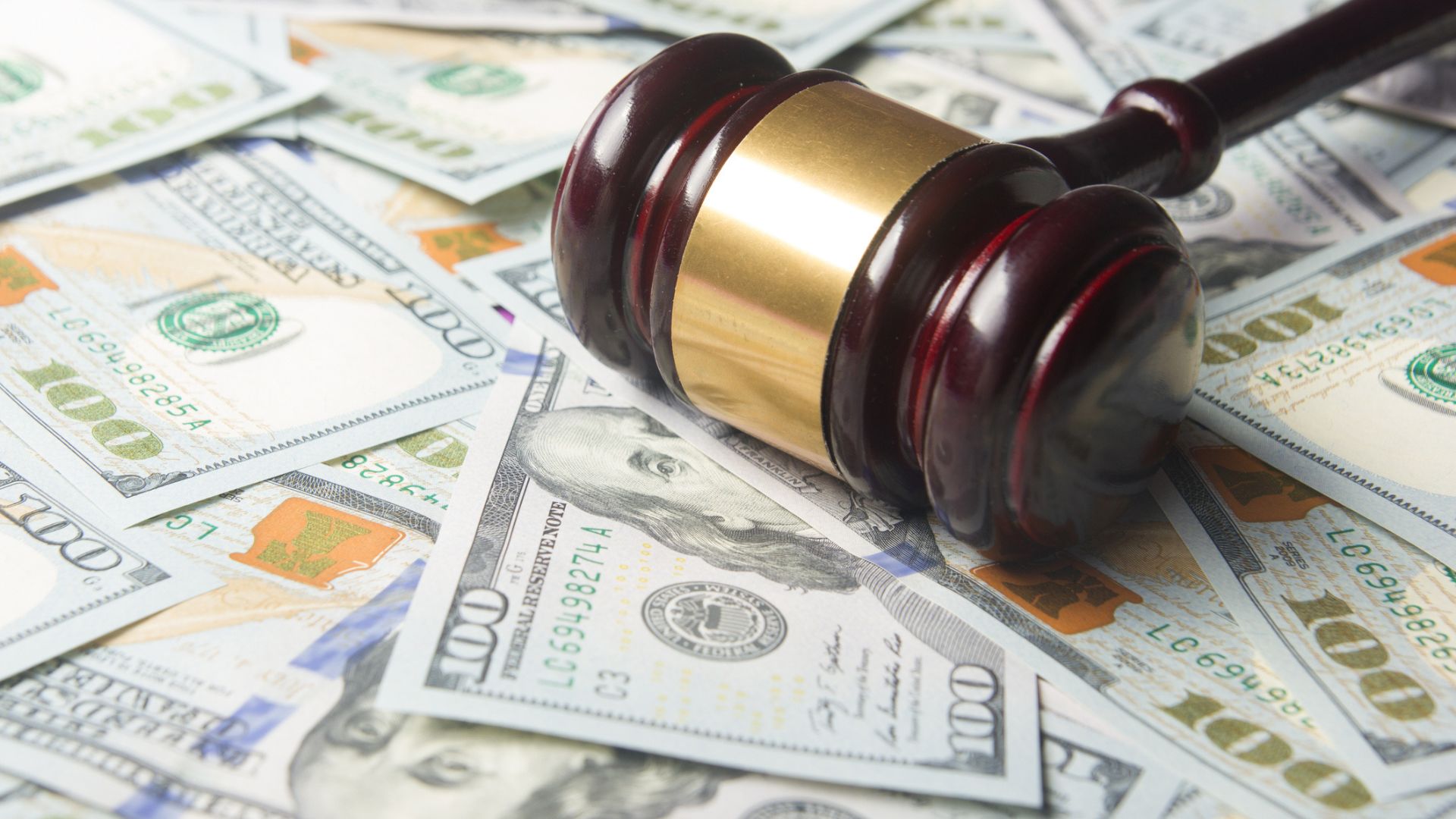 A judge’s gavel sitting on top of loose cash