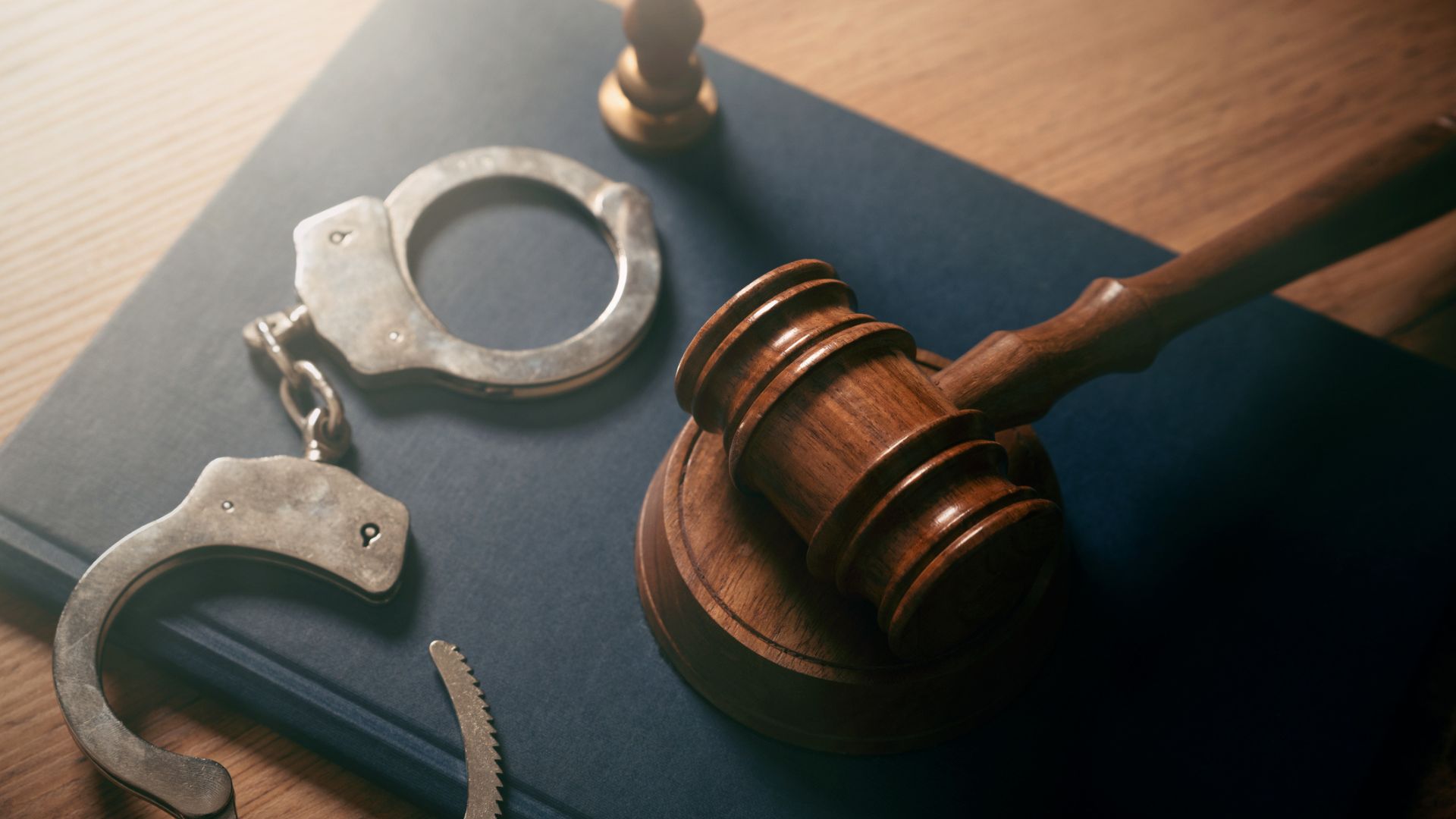 handcuffs and a wooden judge's gavel sitting side by side