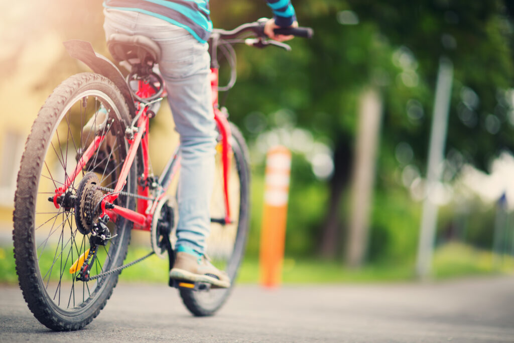 child on a bicycle at asphalt road in early morning