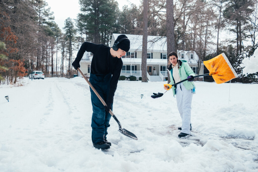 teenagers shoveling snow