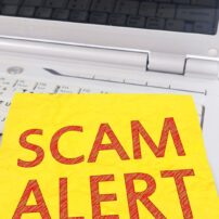 A Scam alert sign on a laptop with a stethoscope