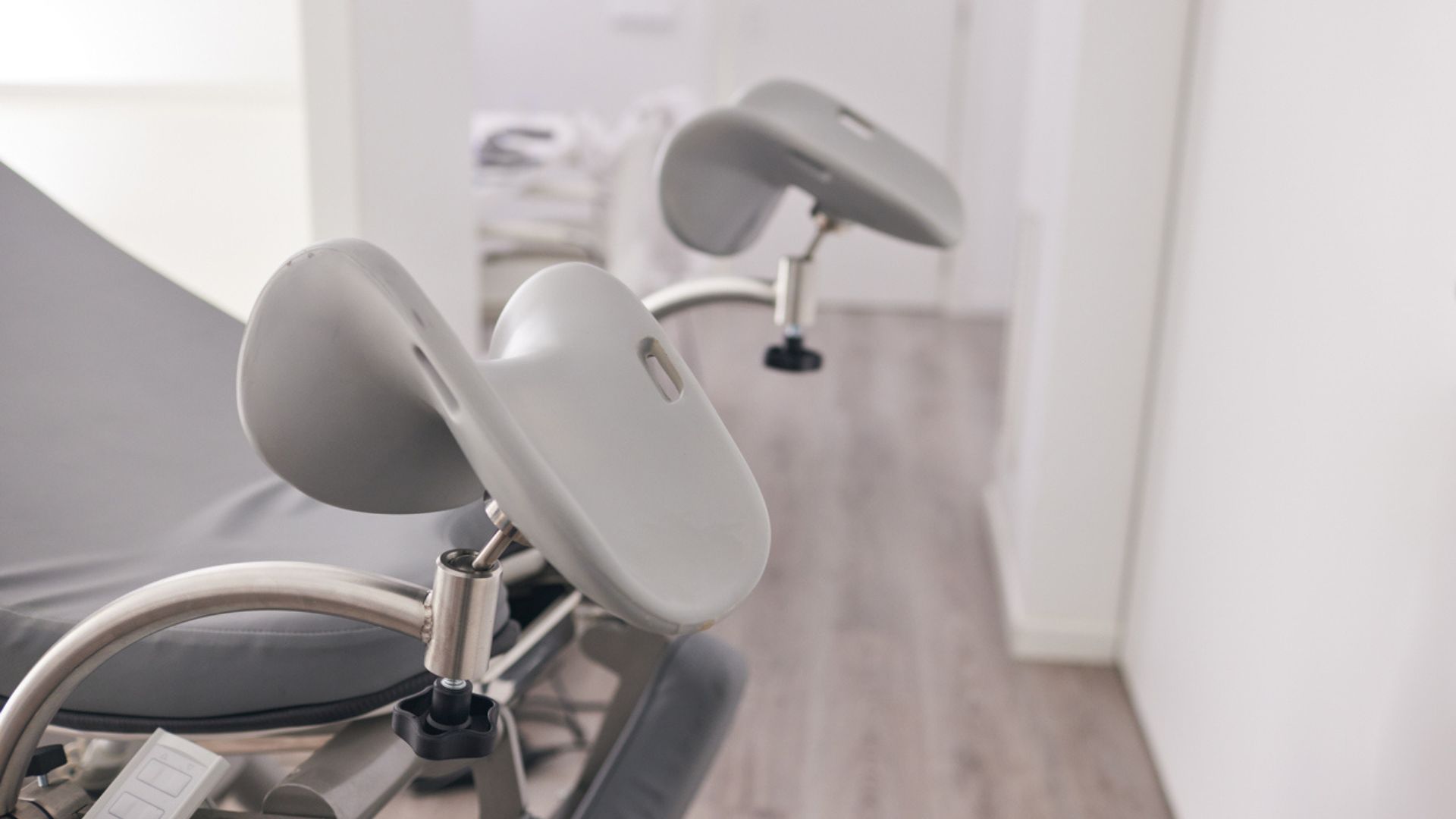 A gynecologial exam chair with an upclose on the stirrups