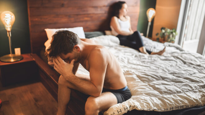 A Lover couple lies in bed, no sexual desire. Men on sit on side of the bed