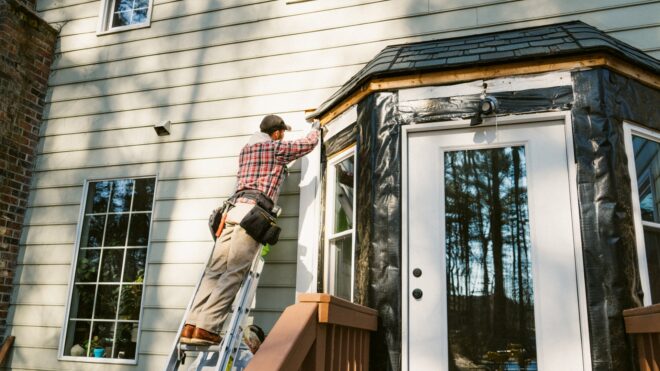 man repairing siding