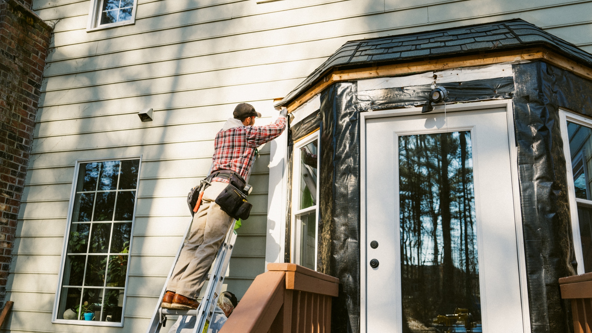 man repairing siding