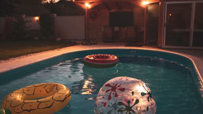 A backyard swimming pool with inflatables inside