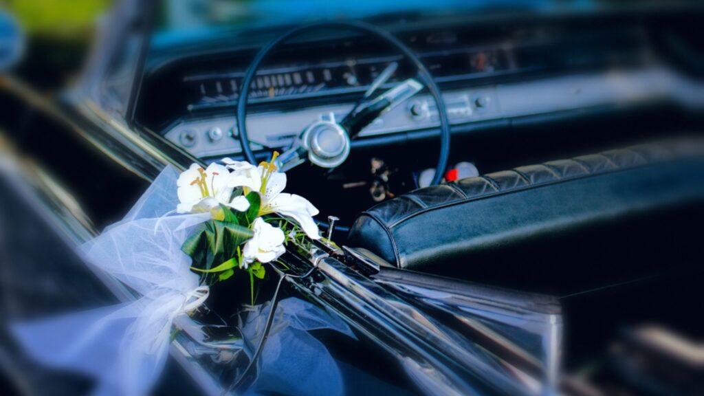 A car with a wedding bouquet at the side