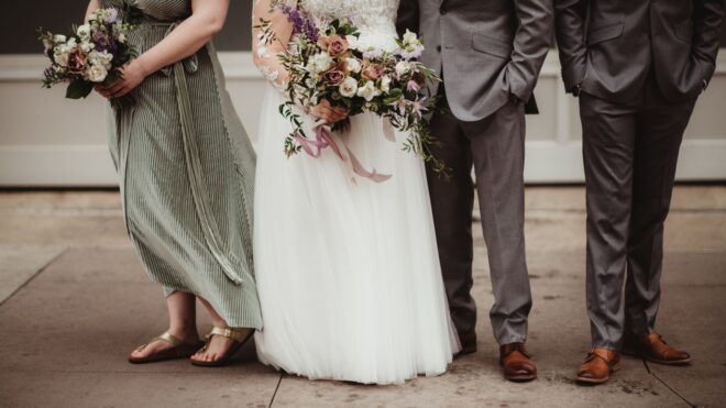 A wedding party showing a groom, bride, bridesmaid, and groomsman