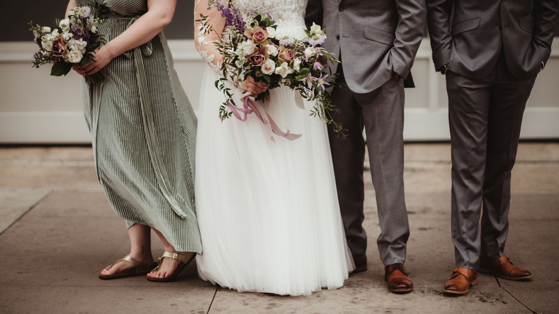 A wedding party showing a groom, bride, bridesmaid, and groomsman