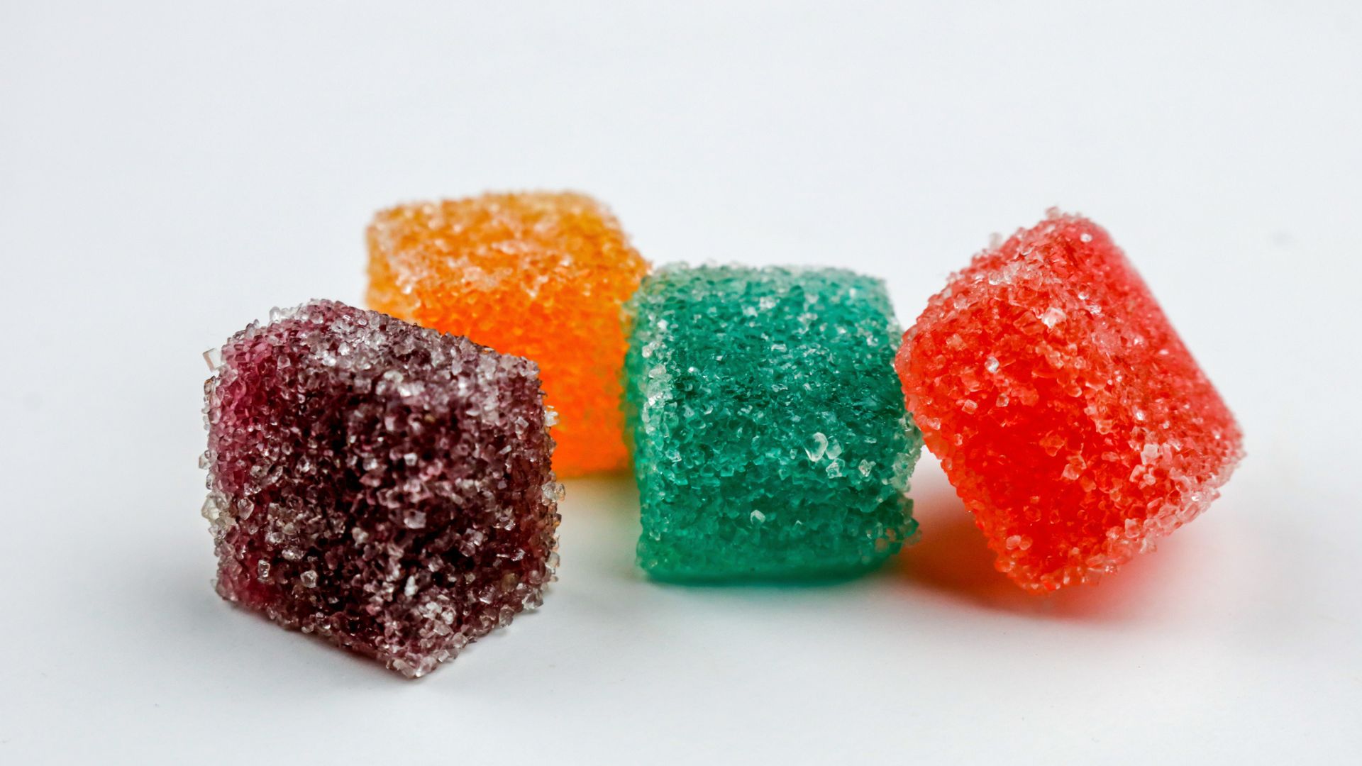 Four colorful gummies covered in sugar