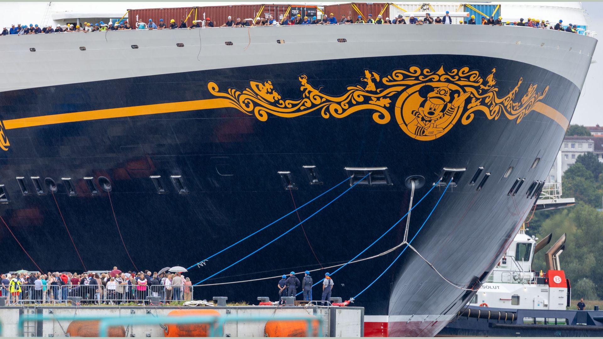 Shipyard workers watch from on board as the cruise ship Disney Adventure