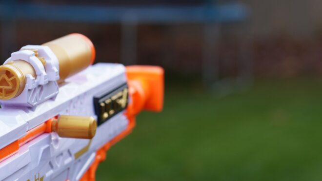 A close-up shot of someone pointing a toy rifle outdoors