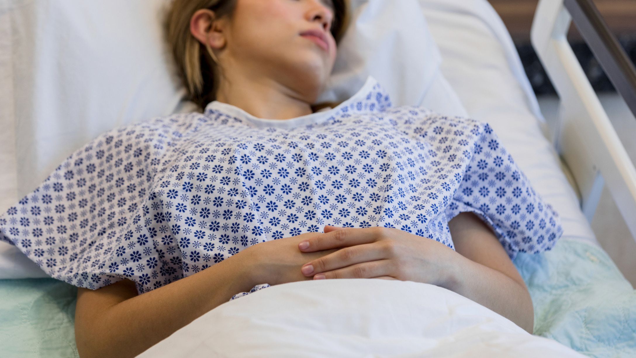 A female patient in a hospital gown laying in bed