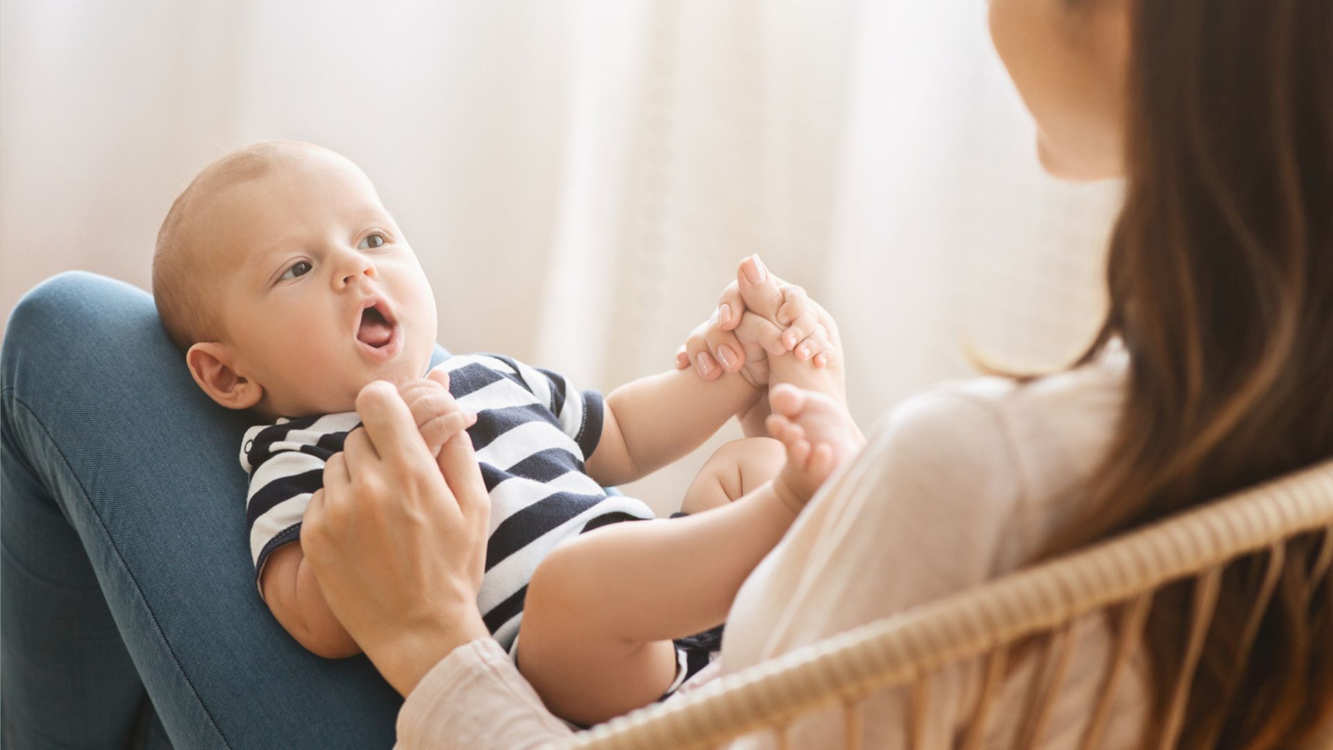 A mom playing with a baby boy on her lap