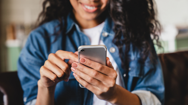 Cropped shot of an african-american young woman using smart phone at home