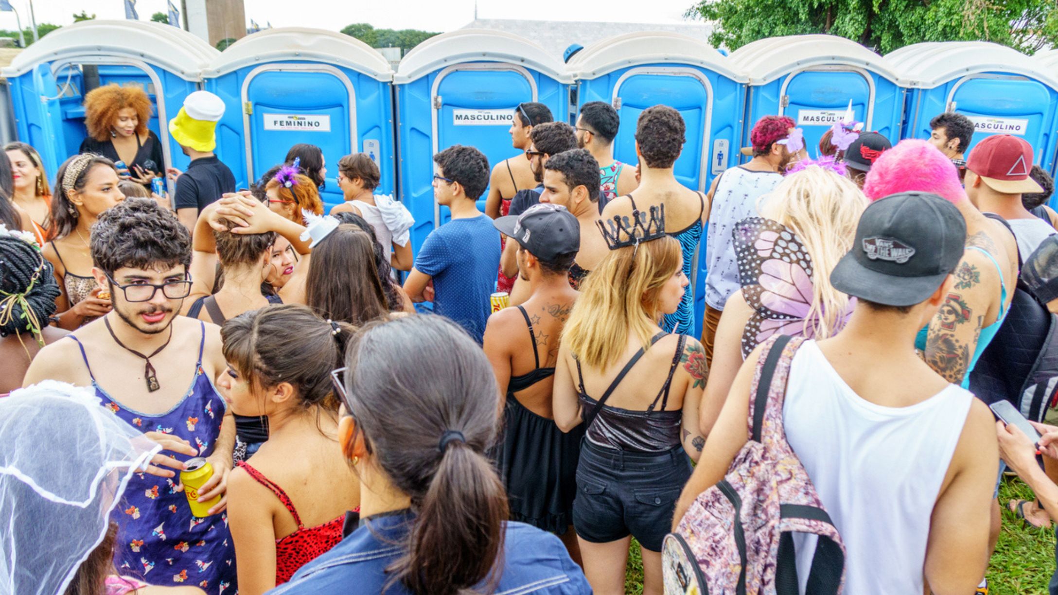 A group of people standing in front of a row of porta potties