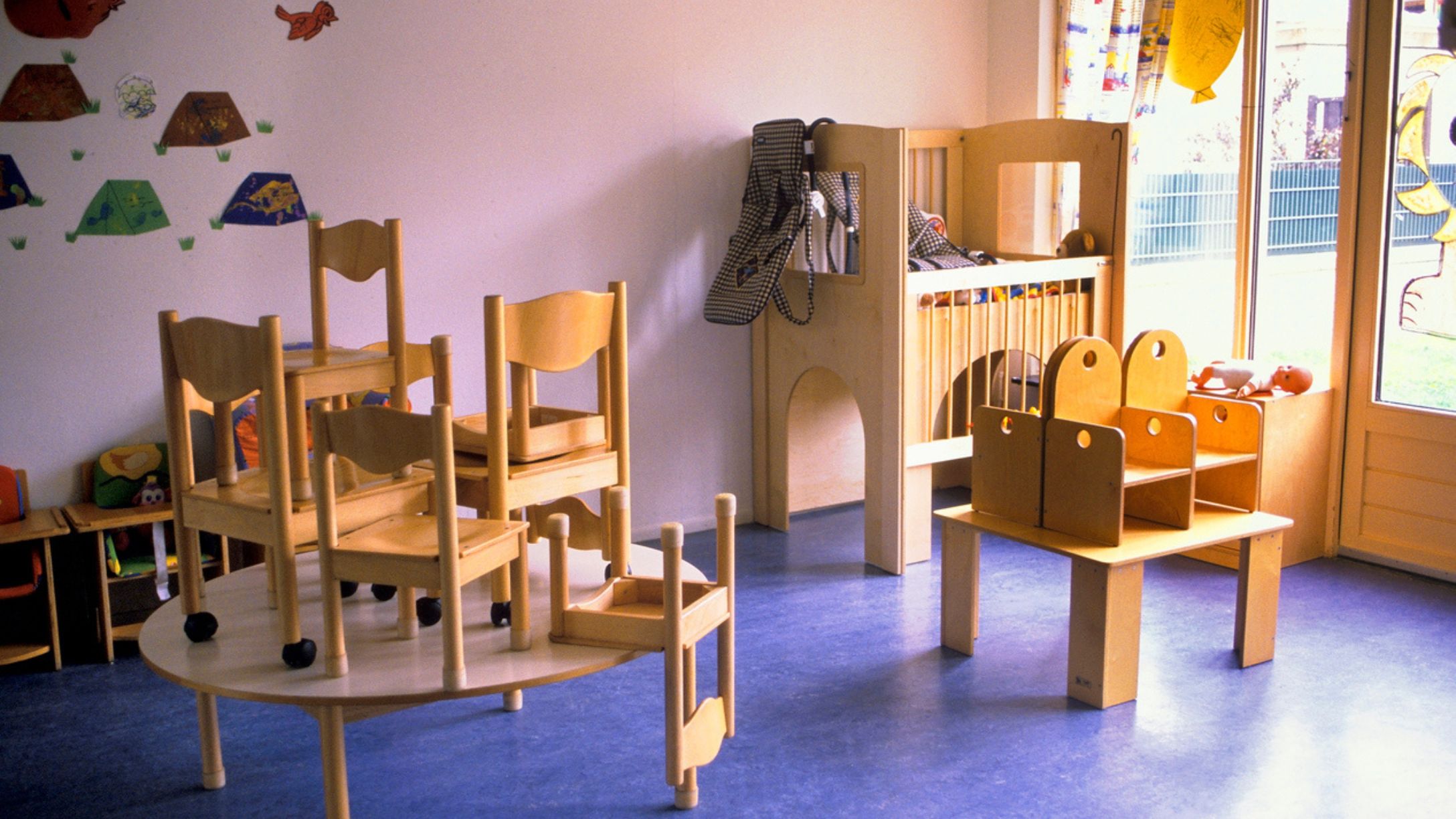 An empty daycare with wooden furniture stacked