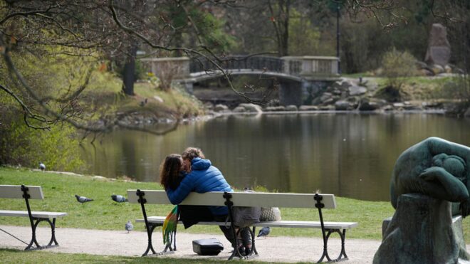 Two people kissing on a bench in the Ujazdow Park in Warsaw, Poland
